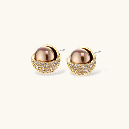 Elegant spherical pendant necklace and earrings set featuring crystal-pavé bottom half in gold or silver finish on white background.