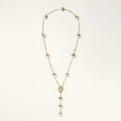 Gold-plated lariat necklace with baroque pearls and textured caps on cream background, showing adjustable Y-shaped design.