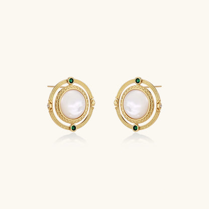 Circular gold stud earrings with iridescent mother-of-pearl center and green zirconia accents on cream background.